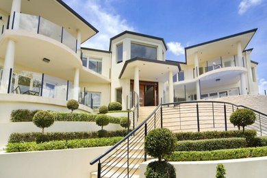 Inspiration for an expansive contemporary two-storey concrete house exterior in Sydney with a flat roof.
