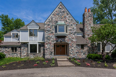 Large elegant gray two-story stone exterior home photo in Grand Rapids