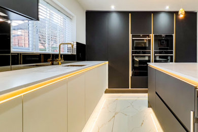 Photo of a large contemporary u-shaped kitchen/diner in Other with a built-in sink, flat-panel cabinets, black cabinets, quartz worktops, metallic splashback, glass tiled splashback, black appliances, ceramic flooring, an island, white floors and white worktops.