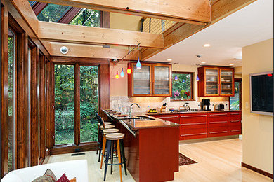 Example of a large eclectic galley light wood floor open concept kitchen design in DC Metro with a drop-in sink, glass-front cabinets, medium tone wood cabinets, granite countertops, beige backsplash, ceramic backsplash, stainless steel appliances and no island