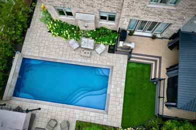 Transitional backyard stone pool landscaping photo in Toronto