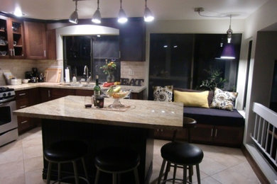 Eat-in kitchen - mid-sized traditional l-shaped ceramic tile eat-in kitchen idea in Los Angeles with a double-bowl sink, shaker cabinets, dark wood cabinets, granite countertops, beige backsplash, ceramic backsplash, stainless steel appliances and an island