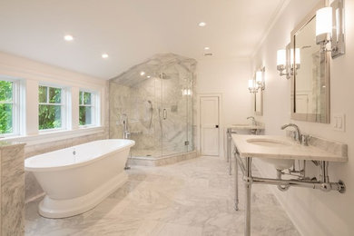 Large master bathroom in New York with a freestanding tub, a corner shower, yellow tile, marble, marble floors, an undermount sink, white floor and a hinged shower door.