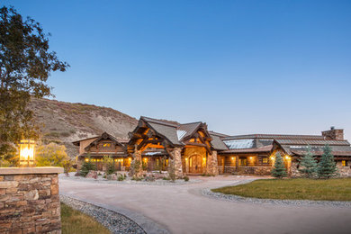 Inspiration for a huge rustic multicolored three-story mixed siding exterior home remodel in Other with a mixed material roof