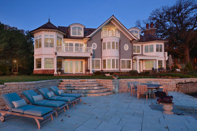Example of a large beach style gray three-story mixed siding gable roof design in Chicago