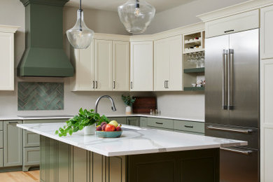 Example of a large classic l-shaped light wood floor and brown floor eat-in kitchen design in Minneapolis with an undermount sink, recessed-panel cabinets, green cabinets, quartz countertops, beige backsplash, porcelain backsplash, stainless steel appliances, an island and white countertops