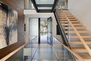 Photo of a contemporary entryway in San Francisco with white walls, a pivot front door and a glass front door.