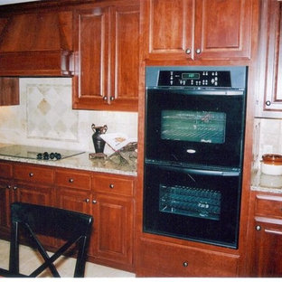 Large traditional kitchen pantry designs - Large elegant l-shaped ceramic floor and beige floor kitchen pantry photo in Little Rock with a double-bowl sink, raised-panel cabinets, dark wood cabinets, granite countertops, beige backsplash, stone tile backsplash and black appliances