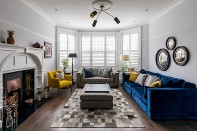 Inspiration for a traditional living room in Other with grey walls, dark hardwood flooring, a standard fireplace and brown floors.