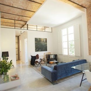This is an example of a large mediterranean formal open plan living room in Barcelona with white walls, concrete flooring and grey floors.