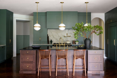 Inspiration for a transitional u-shaped dark wood floor and brown floor kitchen remodel in Philadelphia with an undermount sink, shaker cabinets, green cabinets, gray backsplash, stone slab backsplash, black appliances, an island and black countertops