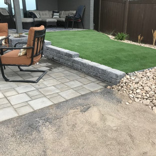 Photo of a small contemporary backyard full sun xeriscape for summer in Other with a retaining wall and concrete pavers.