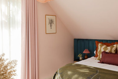 Medium sized master bedroom in Buckinghamshire with pink walls, carpet and beige floors.