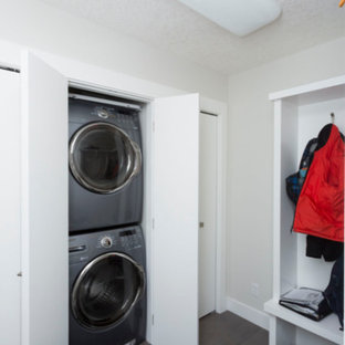 カルガリーの小さいモダンスタイルのおしゃれなランドリークローゼット (ベージュの壁、磁器タイルの床、上下配置の洗濯機・乾燥機、緑の床) の写真