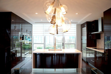 Eat-in kitchen - mid-sized modern u-shaped dark wood floor eat-in kitchen idea in Toronto with an undermount sink, flat-panel cabinets, black cabinets, quartz countertops, beige backsplash, stone tile backsplash, stainless steel appliances and an island
