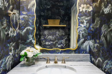 Small transitional wallpaper powder room photo in Dallas with recessed-panel cabinets, medium tone wood cabinets, multicolored walls, an undermount sink, quartz countertops, multicolored countertops and a built-in vanity