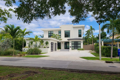 Example of a large trendy white two-story stucco exterior home design in Miami