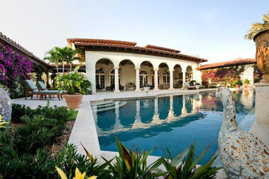 Pool - mediterranean backyard concrete paver and rectangular lap pool idea in Miami