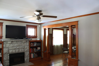 Example of a mid-sized arts and crafts medium tone wood floor family room design in Other with a standard fireplace and a stone fireplace