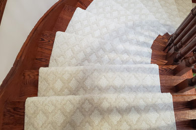 Large minimalist wooden curved wood railing staircase photo in Toronto with wooden risers