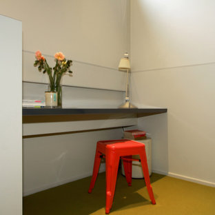 This is an example of a modern study in Melbourne with white walls, carpet, no fireplace, a built-in desk and yellow floors.