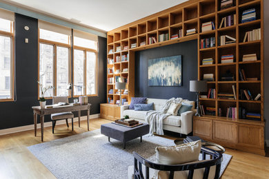Study room - large traditional freestanding desk light wood floor study room idea in New York with blue walls