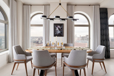 Large contemporary open plan dining in New York with white walls, light hardwood floors, beige floor and recessed.