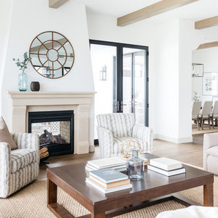 Mediterranes Wohnzimmer mit weißer Wandfarbe, Kaminofen, braunem Boden und hellem Holzboden in Los Angeles