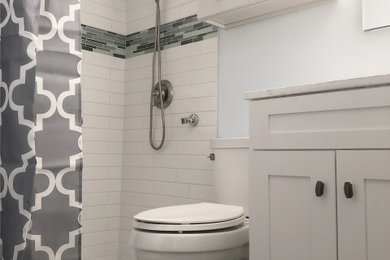 Example of a small trendy master white tile and subway tile vinyl floor, gray floor and single-sink bathroom design in Seattle with recessed-panel cabinets, white cabinets, a bidet, white walls, an integrated sink, marble countertops, white countertops, a niche and a freestanding vanity
