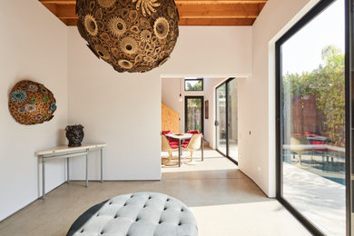 Example of a small danish open concept concrete floor, gray floor and exposed beam living room design in Los Angeles with white walls