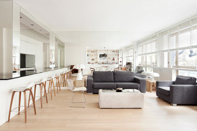 Réalisation d'un grand salon nordique ouvert avec un mur blanc, parquet clair, aucune cheminée, aucun téléviseur et une bibliothèque ou un coin lecture.