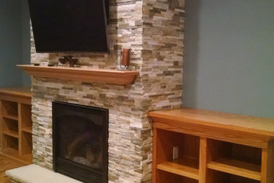 Inspiration for a mid-sized timeless formal and enclosed light wood floor living room remodel in New York with blue walls, a standard fireplace, a stone fireplace and a wall-mounted tv