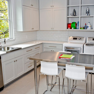 ダラスのトランジショナルスタイルのおしゃれな洗濯室 (ドロップインシンク、左右配置の洗濯機・乾燥機、ステンレスカウンター、グレーのキッチンカウンター) の写真