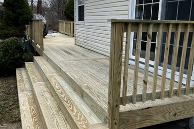 Example of a large backyard ground level wood railing deck design in New York