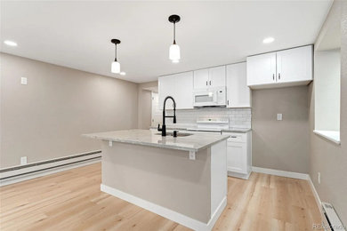 Mid-sized minimalist vinyl floor kitchen photo in Denver with a drop-in sink, white cabinets, granite countertops, white backsplash, subway tile backsplash, white appliances and an island