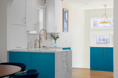 Example of a small tuscan u-shaped medium tone wood floor and brown floor enclosed kitchen design in Denver with a farmhouse sink, shaker cabinets, blue cabinets, quartzite countertops, gray backsplash, stone slab backsplash, paneled appliances, a peninsula and gray countertops