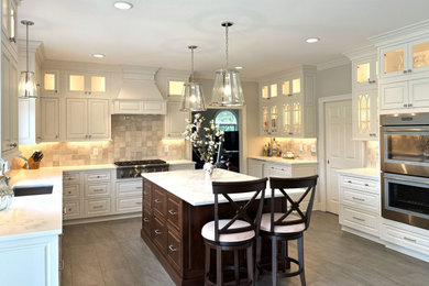 Inspiration for a huge transitional u-shaped porcelain tile and gray floor eat-in kitchen remodel in New York with an undermount sink, beaded inset cabinets, white cabinets, quartz countertops, beige backsplash, stone tile backsplash, stainless steel appliances, an island and white countertops