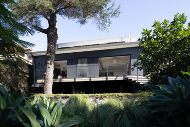 This is an example of a mid-sized contemporary home design in Sydney.