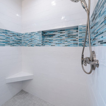 This alcove shower has a built-in hideaway niche and a corner floating seat