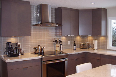 Kitchen - mid-sized transitional l-shaped kitchen idea in Calgary with flat-panel cabinets, brown cabinets, granite countertops, beige backsplash, glass tile backsplash, stainless steel appliances and an island