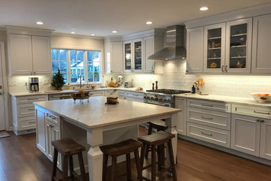 Example of a mid-sized transitional kitchen design in New York with recessed-panel cabinets, white cabinets, granite countertops and an island