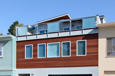 Inspiration for a large modern beige three-story stucco house exterior remodel in San Francisco with a shed roof and a shingle roof