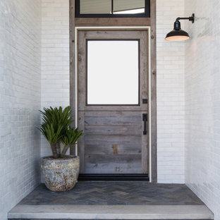 Esempio di una porta d'ingresso stile marinaro di medie dimensioni con pareti bianche, pavimento in ardesia, una porta singola, una porta in legno bruno e pavimento blu