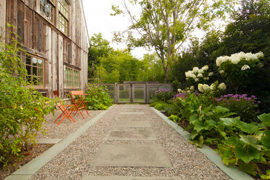 This is an example of a mid-sized traditional side yard full sun formal garden for summer in New York with a garden path and gravel.