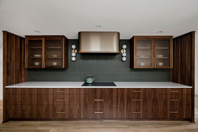 Open concept kitchen - modern medium tone wood floor open concept kitchen idea in Portland with glass-front cabinets, dark wood cabinets, ceramic backsplash and white countertops