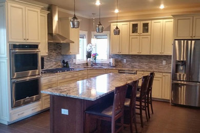 Enclosed kitchen - large country l-shaped enclosed kitchen idea in Other with recessed-panel cabinets, beige cabinets, multicolored backsplash, stainless steel appliances and an island