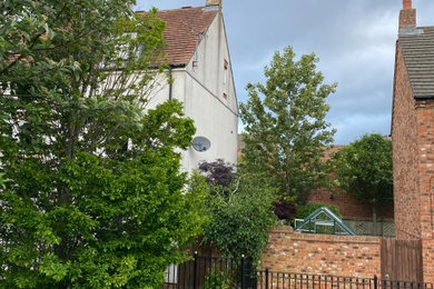 他の地域にある低価格の中くらいなトラディショナルスタイルのおしゃれな家の外観 (漆喰サイディング、デュープレックス) の写真