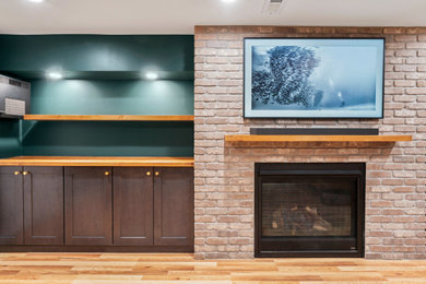 Mid-sized danish underground laminate floor, beige floor and tray ceiling basement photo in Denver with green walls, a standard fireplace and a brick fireplace