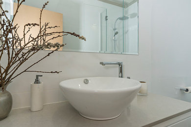 Small contemporary bathroom in Adelaide with flat-panel cabinets, a curbless shower, a two-piece toilet, white tile, porcelain tile, white walls, porcelain floors, a vessel sink and granite benchtops.