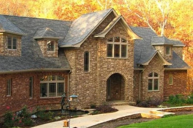 Inspiration for a beige two-story stone exterior home remodel in Other